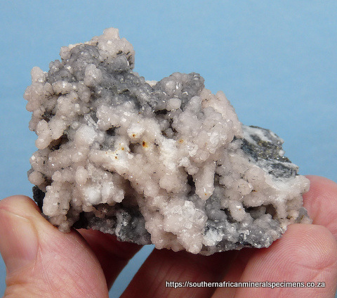 Pink to greyish smithsonite crystals on conglomorate matrix